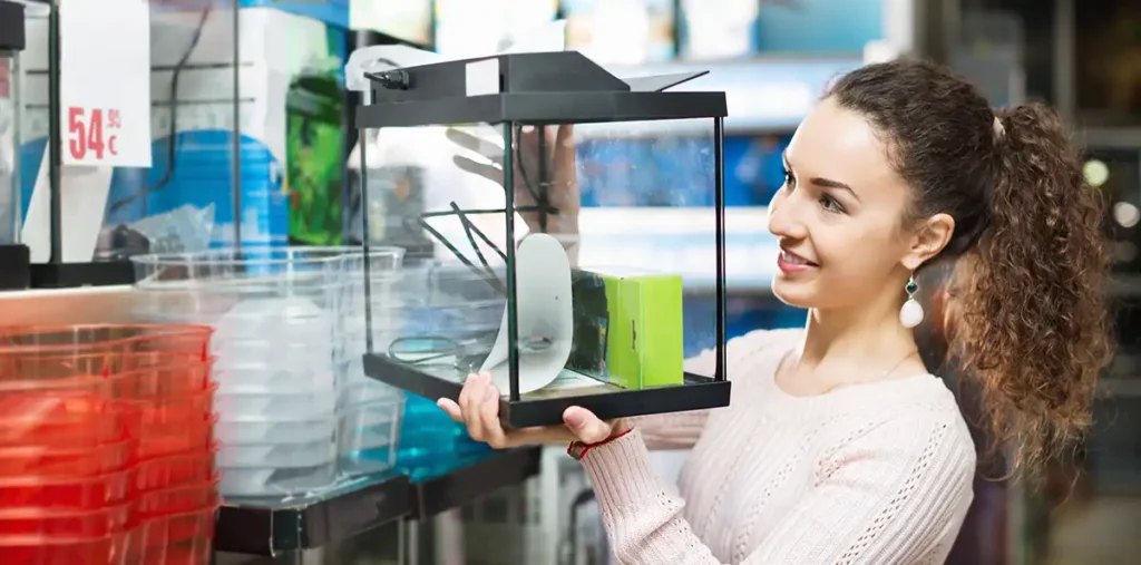 Das richtige Aquarium finden. Eine Frau sucht ein passendes Aquarium aus